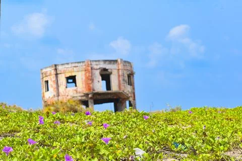 An old decrepit white building faces the sea near the Perupalem beach. India. Stock Photos