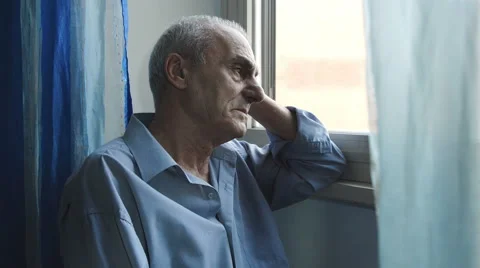 Old depressed man at the window: sadness, loneliness, depression Stock Footage