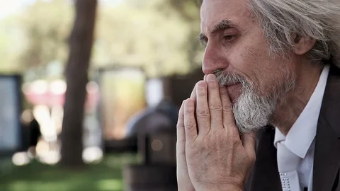 An old desperate gray-haired man with a beard prays and cries Stock-Footage 96548220