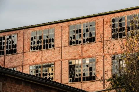 Old destroyed brick house ruin with broken windows Stock Photos
