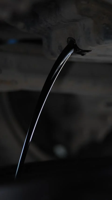 Old dirty black engine oil draining out from a car. Stock Footage 343756331