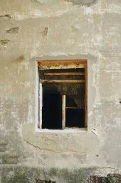 The old dirty broken window on the old dirty wall with cracks. Stock Photos