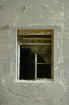 The old dirty broken window on the old dirty wall with cracks. Stock Photos