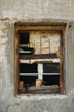 The old dirty broken window on the old dirty wall with cracks. Stock Photos