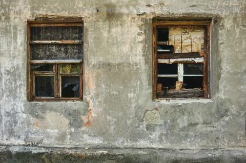 The old dirty broken window on the old dirty wall with cracks. Stock Photos
