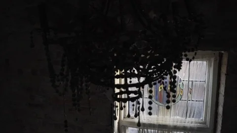 Old dirty chandelier hangs in front of window in abandoned mansion 스톡 동영상 101354519