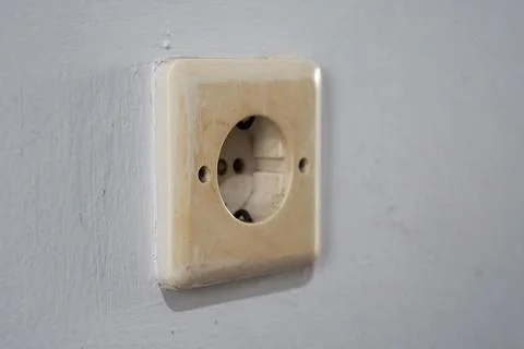 Old Dirty Electrical Socket on Textured White Wall for Renovation Concept 库存照片