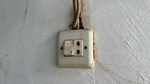 Old Dirty Electrical Switch and Power Socket on Damaged Wall Stock Photos