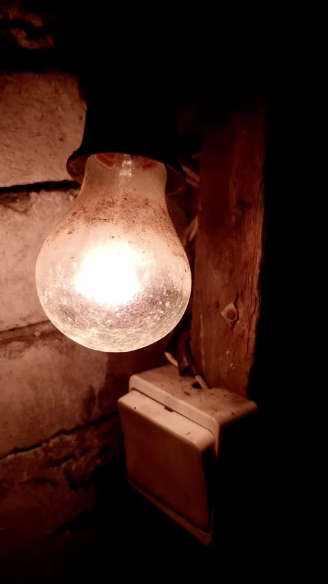 Old Dirty Incandescent Light Bulb Glowing on Rustic Weathered Brick Wall Stock Footage 339002272