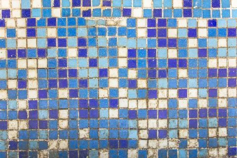 Old dirty wall of small blue and white ceramic tiles. rough surface texture Stock Photos