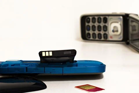 Old disassembled push-button telephone with damaged swollen battery Stock Photos