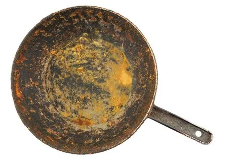 Old disgusting stained rusty cast iron pan with burnt fat and food leftovers Stockfoto's