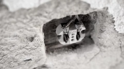 Old dismantled electric socket with a ceramic base in the clay wall of an old Stock Footage 218339069