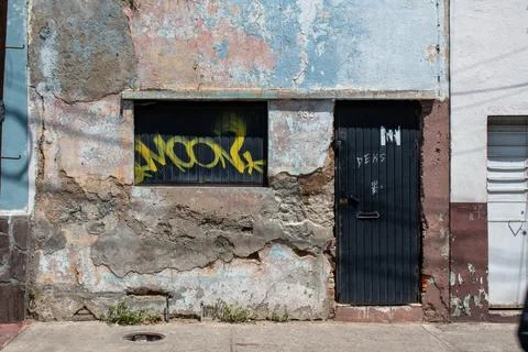 Old distressed building facade with graffiti in Guadalajara, Mexico Stock Photos