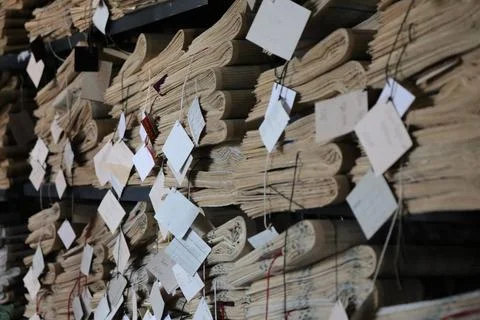 Old documents stored on shelves with tags in a library setting Stock Photos