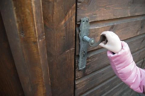 A old door with hand on the handle. Stock Photos