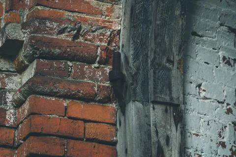 Old door hinges in the red brick wall of the former stable Stock Photos