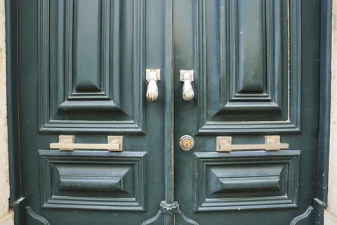 Old doorknocker with hand shape on old wooden door Stock Photos