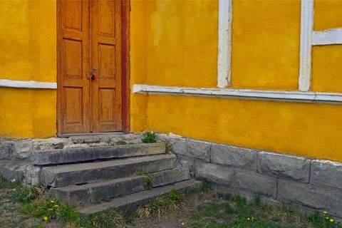 Old doors on a yellow wall and concrete stairs Stock Photos
