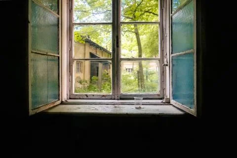 Old double-glazed window in the darkness of the room of an abandoned building Stock Photos