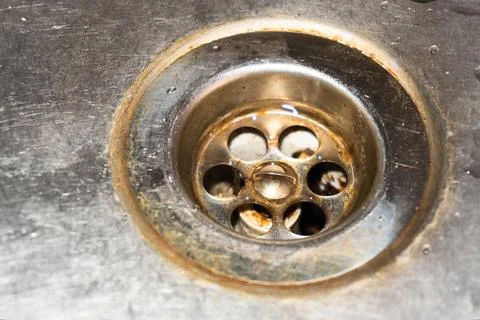 Old drain in the sink, rusty drain in a metal sink, broken sink, broken drain in Stock Photos