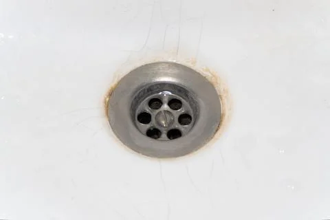 Old drain in the sink, rusty drain in a white sink, broken sink, broken drain in Stock Photos