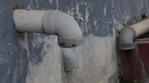 Old Drainage Pipes on a Weathered Concrete Wall Stock Footage 345334477