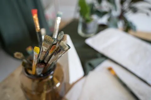Old drawing brushes are stored in a stand. Artist's Studio Stock Photos