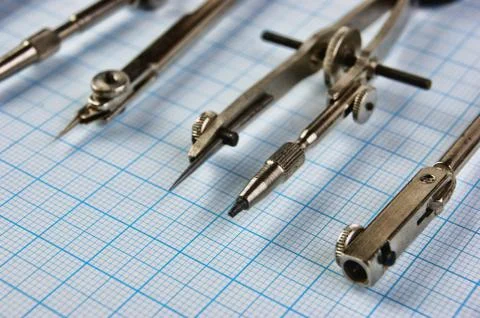 Old drawing tools on graph paper Fotos de archivo