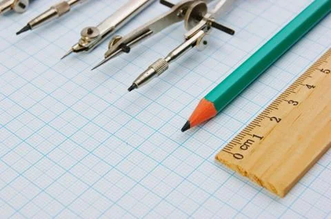 Old drawing tools on graph paper Fotos de archivo