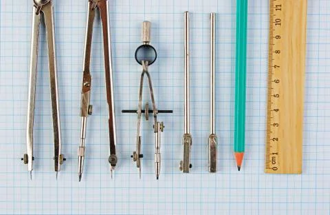 Old drawing tools on graph paper Fotos de archivo