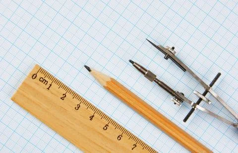 Old drawing tools on graph paper Fotos de archivo