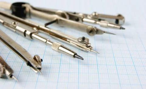 Old drawing tools on graph paper Fotos de archivo