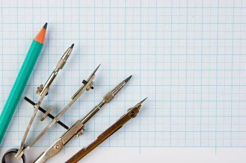 Old drawing tools on graph paper Fotos de archivo