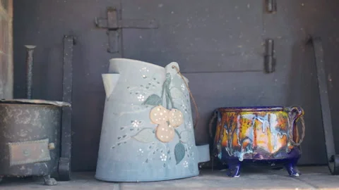 Old dusty crockery on brick shelf, painted porcelain bowls and copper jug Stock Footage 269826257