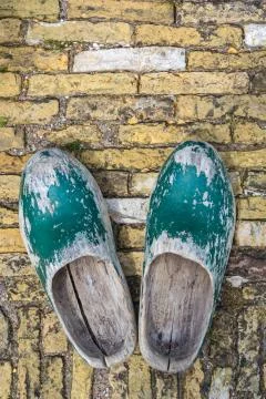 Old dutch clogs on a brick background Stock Photos