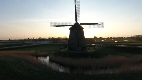 Old dutch windmill during sunrise with nice bokeh effect shot by a drone while m 動画素材 128385147