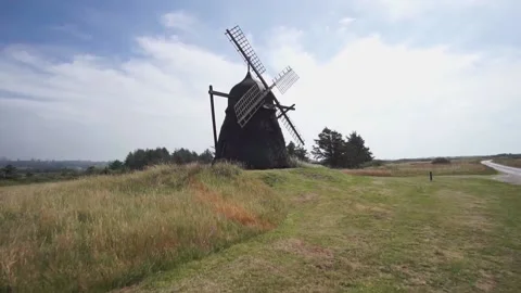 Old Dutch windmill in a meadow during summer. Sunset and lens flare. Video stock 140393155