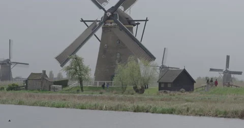 Old dutch windmills in an open land next to a canal Stock Footage 145144665