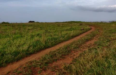 An old earthen road path running beyond the hills Stock Photos