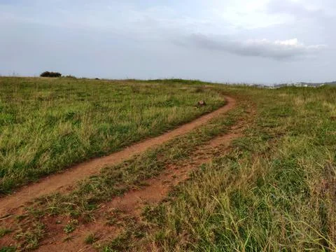 An old earthen road path running beyond the hills Stock Photos