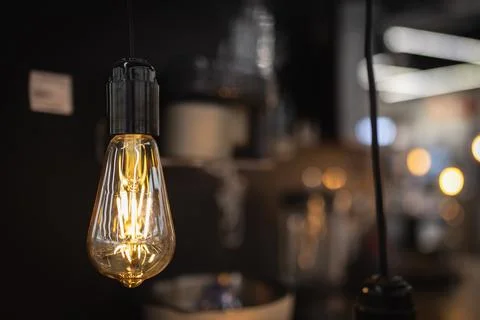 Old Edison lamp in warm light with filaments in the interior of the loft Stock Photos