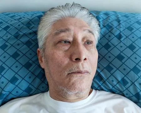 Old Elderly Asian Man Resting on a Pillow Stock-Fotos