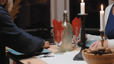 Old elderly couple having dinner man opens lid to macbook laptop computer Stock Footage 149203787