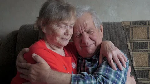 Old Elderly Couple Hugging Sitting On Couch In House Stock Footage 179457622