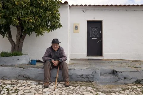 Old elderly man sitting outside his door Stock Photos