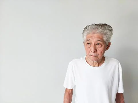 Old Elderly Thin Asian Man Standing Against Wall Background 스톡 사진