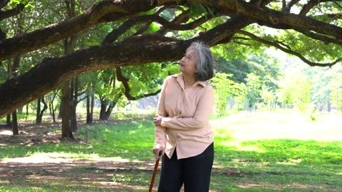 Old elderly woman using a walking stick to help her walk balance and walking  Stock Footage 172250561