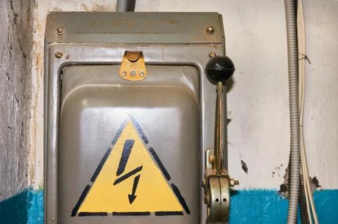 An old electric high-voltage switch with a painted danger sign. Stock Photos