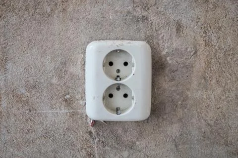 Old electric plug socket on vintage wall during home renovation, apartment  r Stock Photos